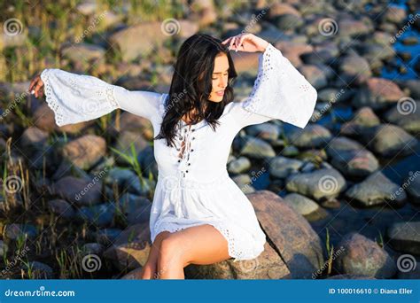 Retrato De La Mujer Hermosa Joven En El Vestido Blanco En La Playa
