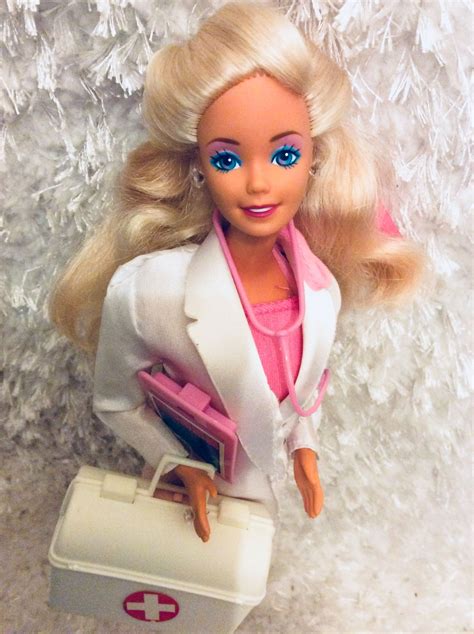 A Barbie Doll With Blonde Hair And Blue Eyes Holding A White Briefcase In Her Hand
