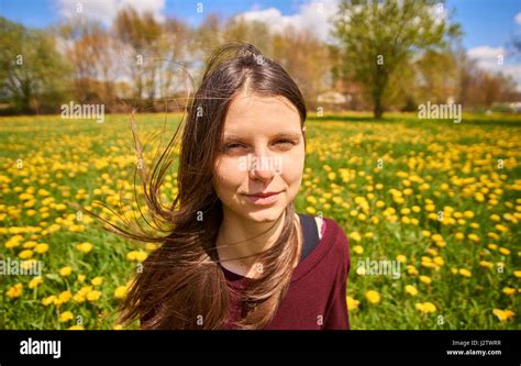 Beautiful Young Woman Relaxing On A Meadow With Many Dandelions In The