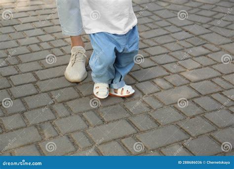 madre apoyando a su hija mientras aprende a caminar al aire libre cerca espacio para texto foto