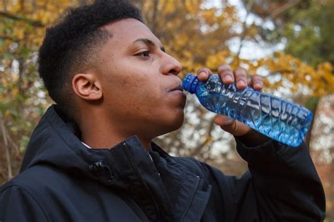 Premium Photo Young Black Man Drinking Water From A Plastic Bottle In
