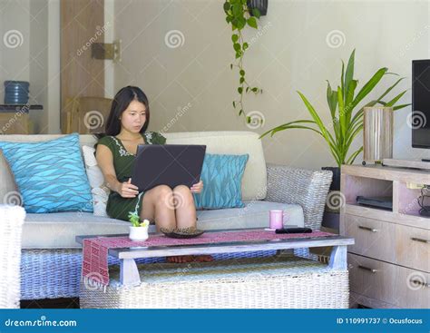 Young Beautiful And Relaxed Asian Chinese Woman On Her 20s Or 30s Sitting Happy At Living Room