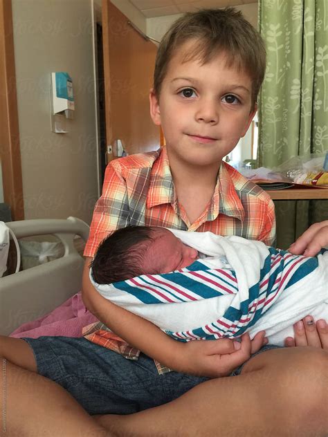 Big Brother Holding His Baby Brother For The First Time By Stocksy