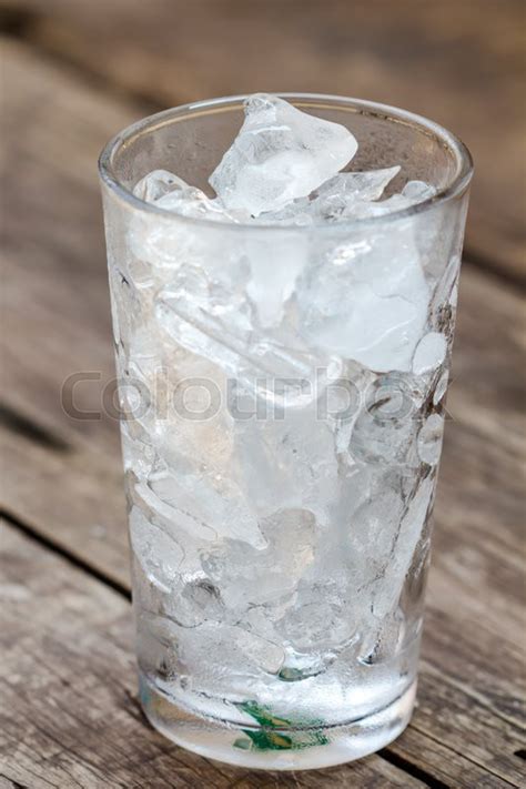 A Glass Of Ice Cubes On Wooden Stock Image Colourbox