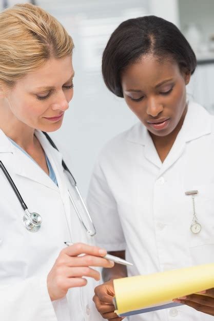 Premium Photo Doctor And Nurse Going Over File Together
