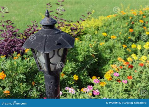 Beautiful Lamp Post In A Garden With Colorful Flowers Stock Photo