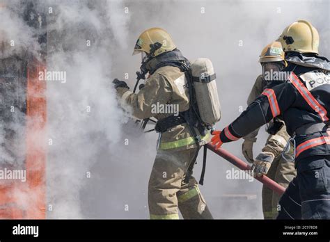 Los Bomberos Extinguen El Fuego De La Manguera De Incendios Usando Un