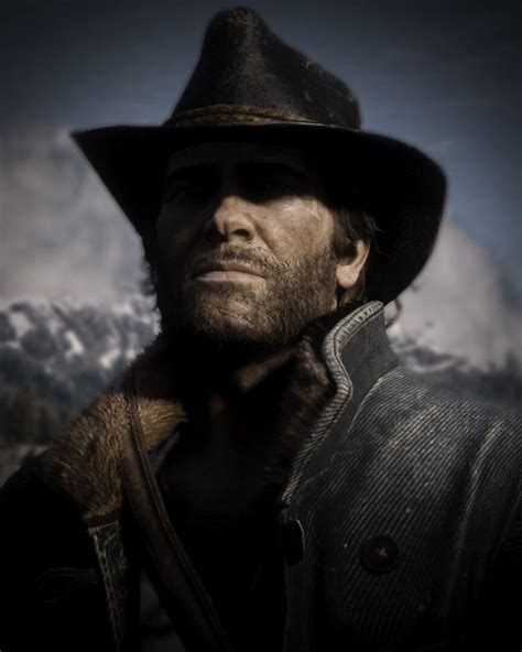 A Man Wearing A Hat And Coat With Mountains In The Background