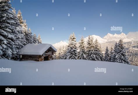 Log Cabin In A Snow Covered Landscape In The Austrian Alps Stock Photo