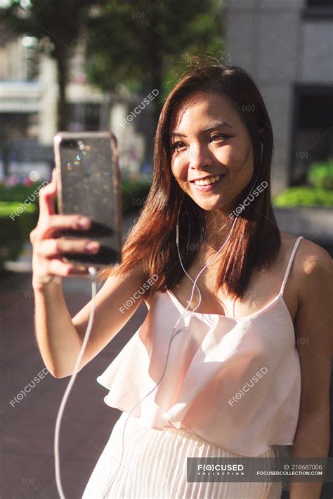 Pretty Asian Girl Taking A Selfie In The Street Outdoors Mobile Stock Photo