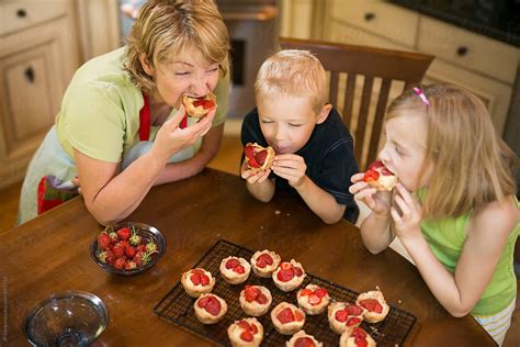 Grandmother And Grandchildren Eating Pastry Custard And Strawberry