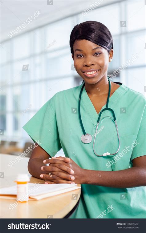 Smiling African American Nurse At Hospital Work Station Lit Brightly