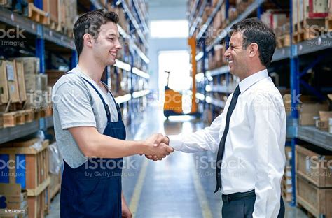 Manager And Employee Handshake In Warehouse Stock Photo Download