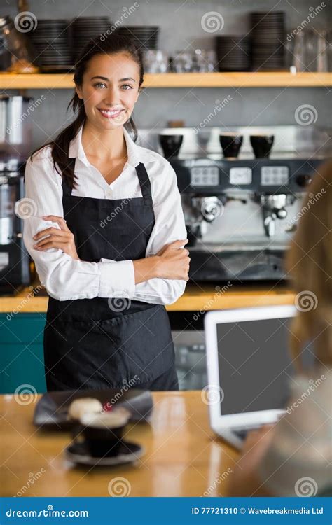 Portrait Of Smiling Waitress Standing With Arms Crossed Stock Photo