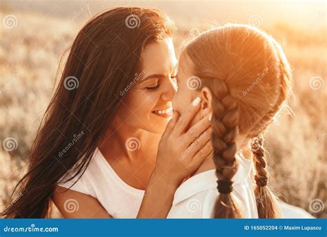 Cheerful Mother Showing Affection To Daughter In Nature Stock Photo