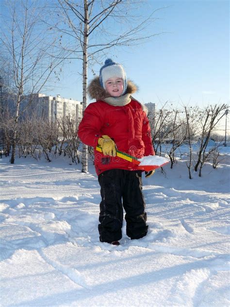 A Boy In Winter Clothes Playing With Snow Stock Image Image Of City