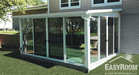 An Enclosed Patio With Sliding Glass Doors On The Side Of It And Grass