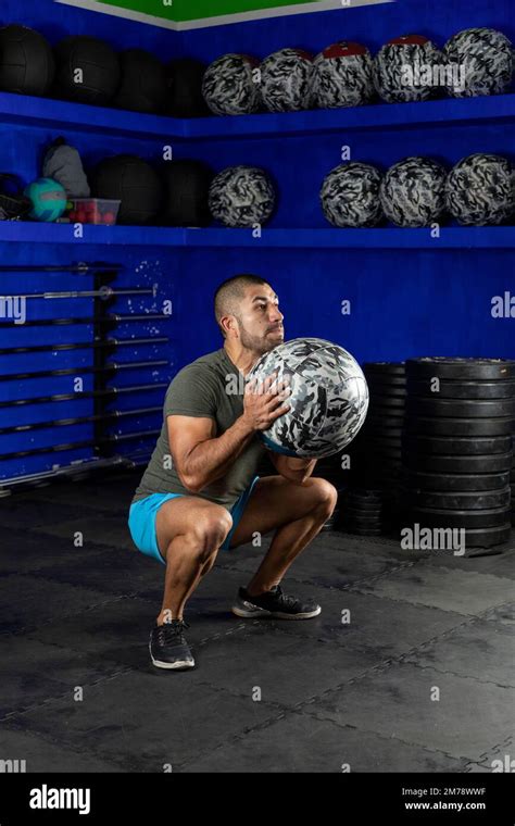 Latin Man Exercising In A Gym Using A Crossfit Medicine Ball Stock