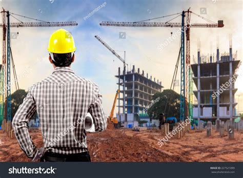 Civil Engineer Working In Building Construction Site Against Sunset Sky