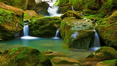 Small Waterfalls On A Mountain River Large Green Rocks