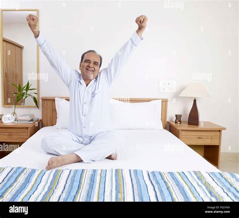 Old Man Stretching Both Hands Sitting On Bed Mr702t Stock Photo Alamy