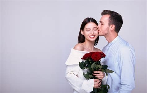 Premium Photo A Young Guy Gives Roses To His Beautiful Womanfriend