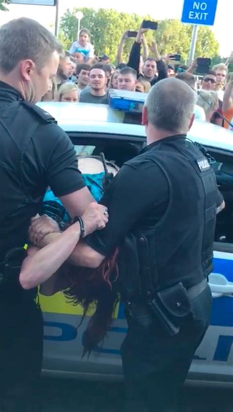 Handcuffed Woman Tries To Climb Out Of Police Car Window And Spits At Officers When They Try