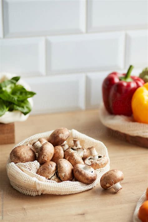 Pile Of Fresh Mushrooms In Biodegradable Bag In Kitchen By Stocksy
