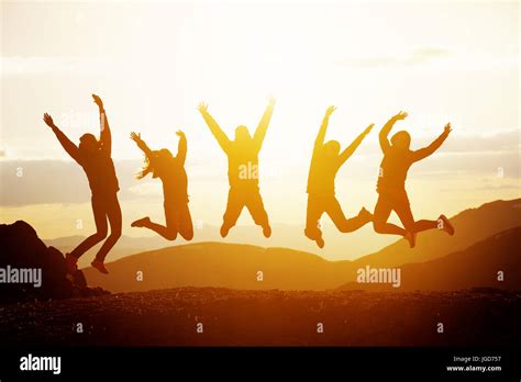Happy Friends Jumping Sunset Mountains Stock Photo Alamy