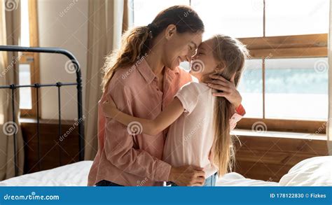 Affectionate Young Mother Cuddling Little Adorable Daughter In Bedroom