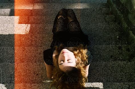 a redhead woman lying on a stairs by stocksy contributor anna malgina stocksy