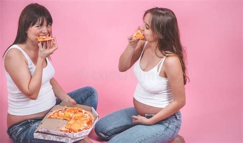 Nutrition Concept Pregnant Women Eating Pizza On A Pink Background