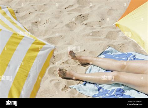 Legs Of Sunbathing Girl On Beach Stock Photo Alamy