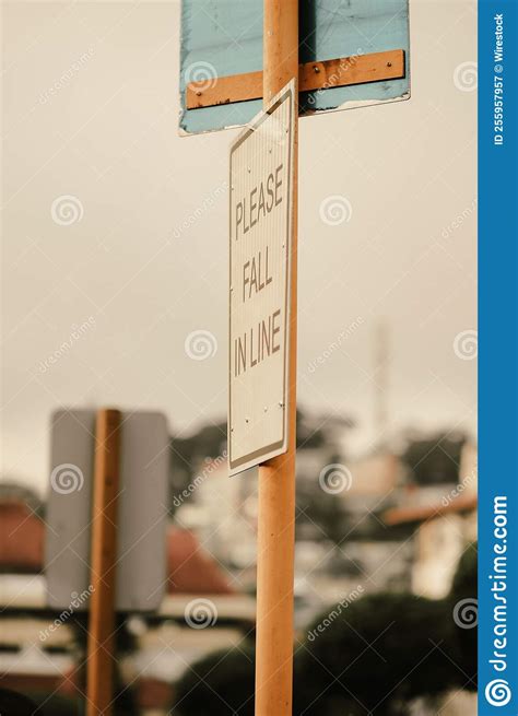 Vertical Closeup Of A Road Sign With Please Fall In Line Inscription