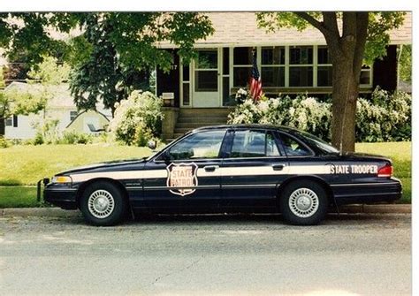 A Police Car Parked In Front Of A House With An American Flag On The Door