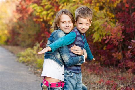 Junge Schwester Mit Kleinem Bruder Im Herbstpark Stockfoto Bild Von