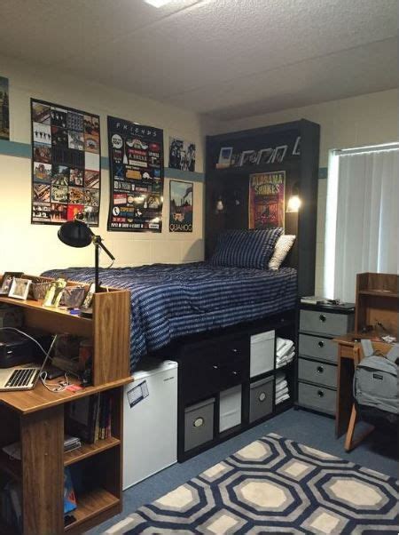 a dorm room with a bed desk and computer on top of the dressers