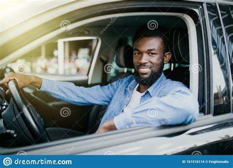 Happy Young African American Man Driving A Car On Street Roads Stock
