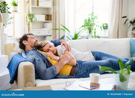Happy Couple In Love On Sofa Indoors At Home Sleeping Stock Photo