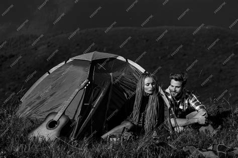Premium Photo Camping Happy Man And Woman Smiling And Playing Songs At The Guitar While
