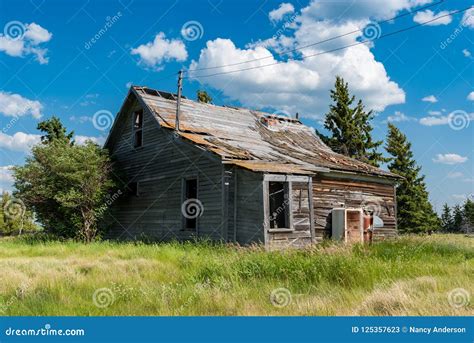 Old Abandoned Prairie Farmhouse Surrounded By Trees Tall Grass And