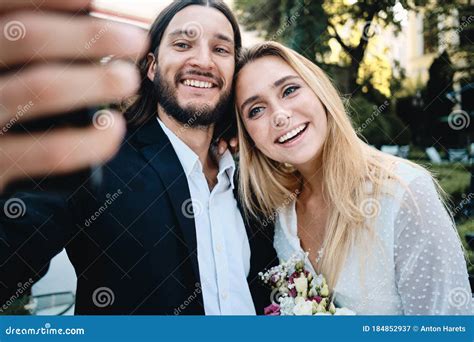 Young Attractive Smiling Groom And Bride Joyfully Taking Selfie Outdoor