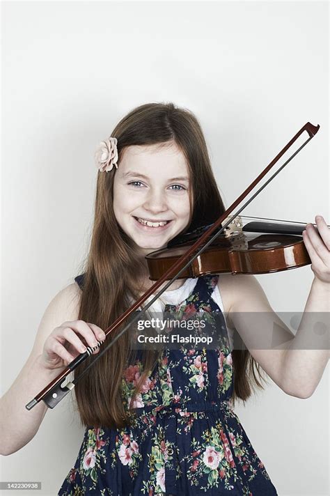 Portrait Of Girl Playing Musical Instrument High Res Stock Photo