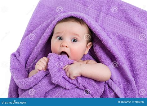 Newborn Baby Lying Down And Smiling In A Purple Towel Stock Image