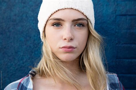 pretty teen girl with long blonde hair wearing a white beanie by stocksy contributor curtis