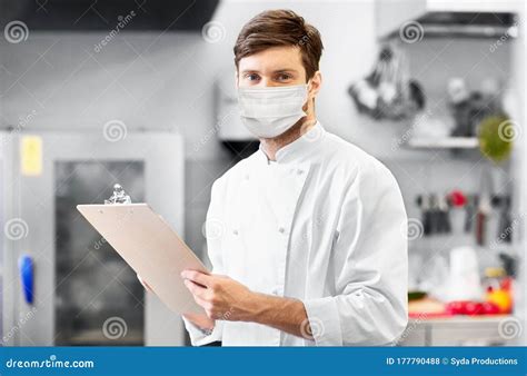 Chef With Clipboard In Face Mask At Restaurant Stock Photo Image Of