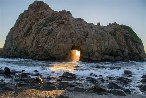 The Sun Is Shining Through An Opening In The Rock Formation At The