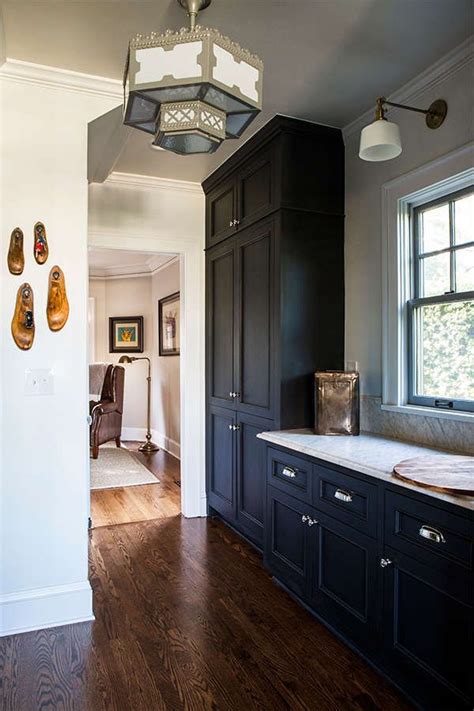 With the contrast between the different types of material in the cabinets and countertops, any kitchen can be transformed with a deep wooden color in the floors. A dark blue kitchen with dark wood flooring. | Dark blue ...