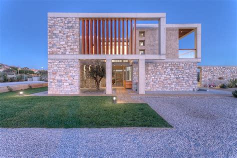 A Modern House With Stone Walls And Grass