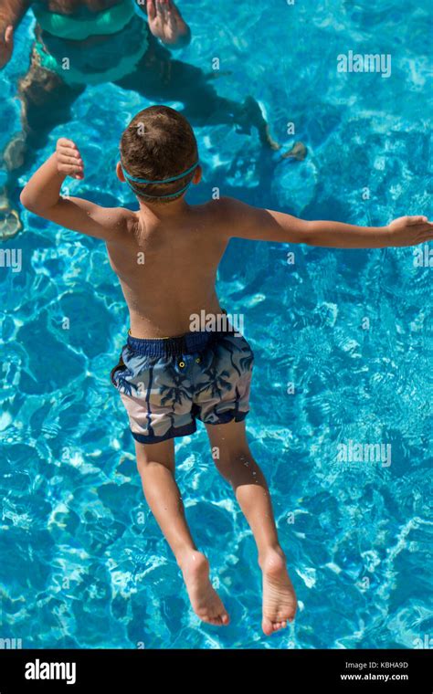 Young Boy Jumping Into A Swimming Pool Stock Photo Alamy